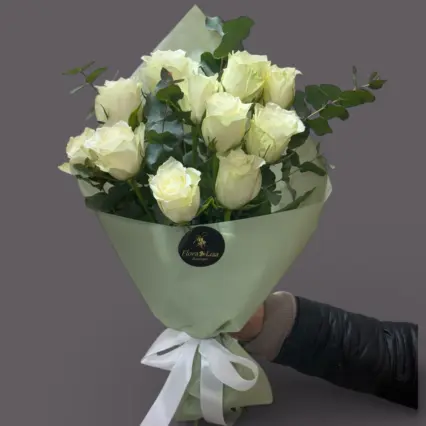 buchet elegant compus din 11 trandafiri albi, eucalipt și verdeață decorativă, atent ambalat